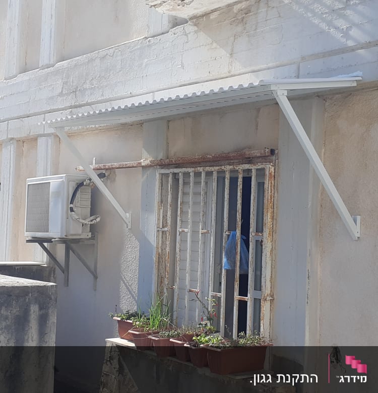 סוכך אלומיניום מעל חלון עם סורגים